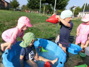 Kinder planschen am Badetag im Wasser