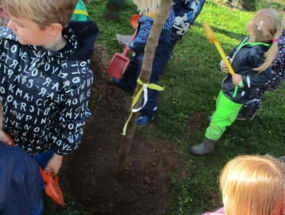 Kinder schaufeln Erde in das Loch