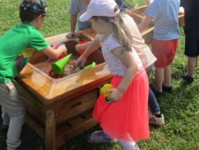 Kinder spielen an Wasserbecken