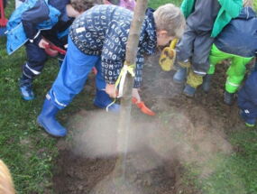 Kinder schaufeln Erde in das Loch