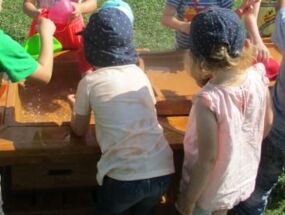 Kinder spielen an Wasserbecken