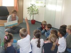 Die Kinder lesen ein Buch über Umweltverschmutzung durch Müll